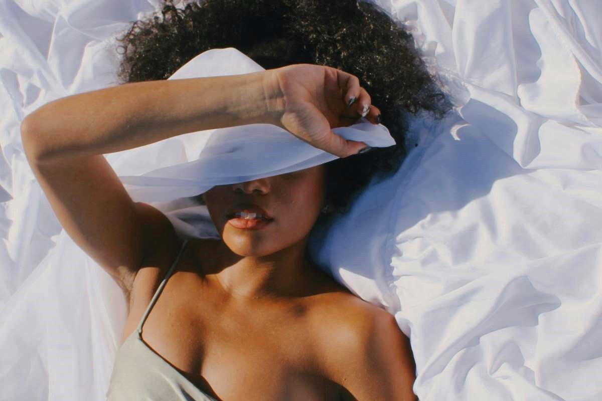 Photo: The Earthy Jay via <a href="https://www.pexels.com/photo/woman-lying-down-and-covering-face-with-white-fabric-14608110/" rel="noopener" target="_blank">Pexels</a>